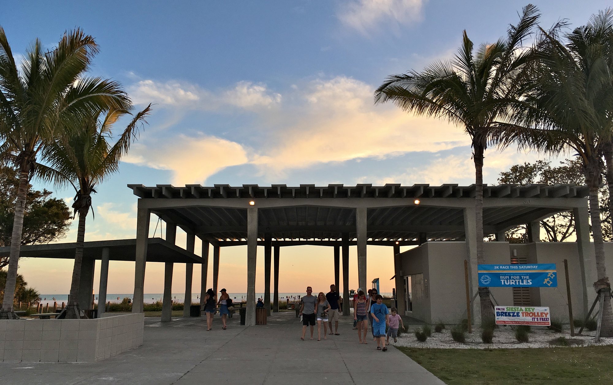 Siesta Key Beach Pavilion plaza at sunset with trolley signage